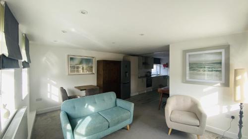 a living room with a blue couch and a chair at The Suffolk Hotel in Haverhill