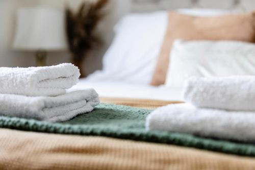 a pile of towels sitting on top of a bed at Jungle House in Chichester
