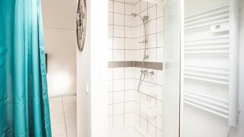 une salle de bain avec une douche avec un rideau de douche bleu dans l'établissement Smart Confort 13 - Appartement confort et stylé, à Troyes