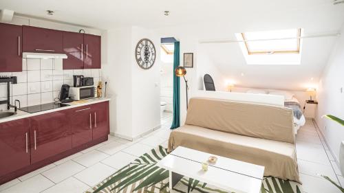 Il dispose d'une cuisine et d'un salon avec un canapé et une table. dans l'établissement Smart Confort 13 - Appartement confort et stylé, à Troyes