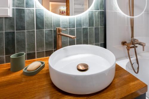 a bathroom with a white sink on a wooden counter at Kora Apartment in Kończyce Małe