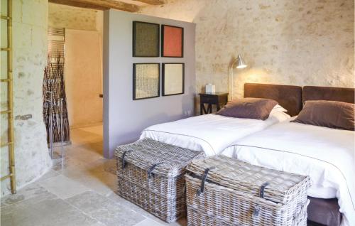 a bedroom with two beds and a stool in it at 3 Bedroom Awesome Home In Cheille Bourg in Cheillé