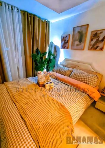 1 dormitorio con 1 cama con edredón de naranja en Azure Staycation by Oveecation Suites, en Manila