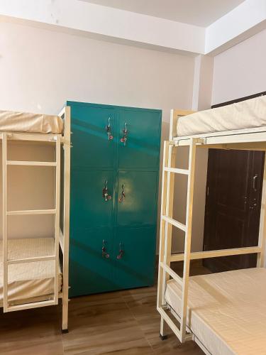 a room with two bunk beds and a blue locker at Thikana by Mulaqat in Siliguri