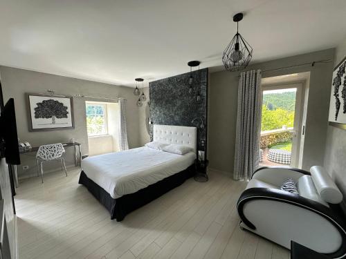 a bedroom with a bed and a chair and a window at Château de la Falque, The Originals Relais in Saint-Geniez-dʼOlt