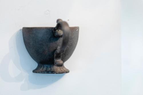 a black cup is hanging on a wall at Jungle House in Chichester