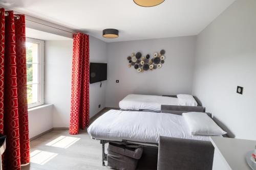 two beds in a room with red curtains at Château de la Falque, The Originals Relais in Saint-Geniez-dʼOlt