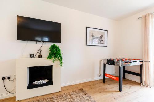 a living room with a fireplace and a flat screen tv at Jungle House in Chichester