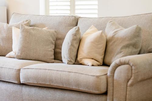a bunch of pillows sitting on a couch at Jungle House in Chichester