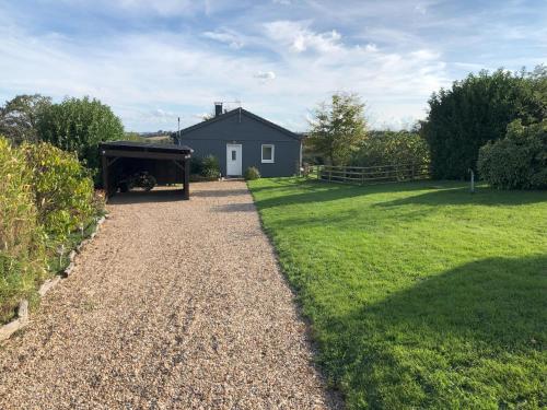 a yard with a house and a gravel driveway at Tri-O-Bois in Thianges