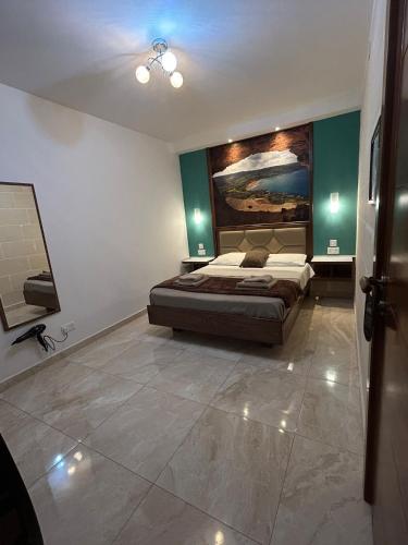 a bedroom with a bed and a painting on the wall at Twenty9th in Nadur