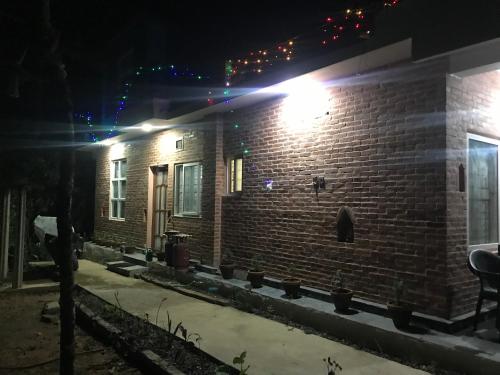a brick house at night with lights on it at Mount Fuji Homestay in Deorāli