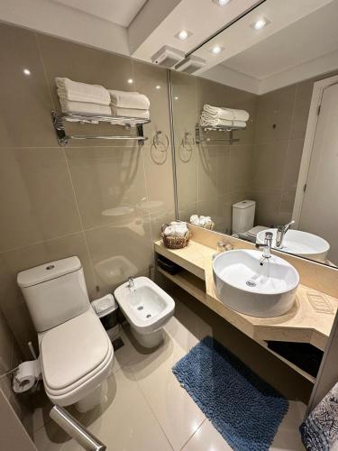 a bathroom with a toilet and a sink and a mirror at Green Park hermoso apartamento vista al lago in Punta del Este