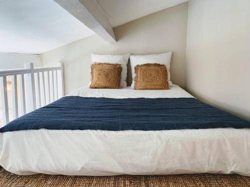 une chambre avec un grand lit avec deux oreillers dans l'établissement Charmante maison de ville 2 chambres avec terrasse, très calme, à Marseillan