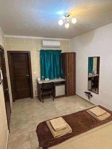 a bathroom with a sink and a desk in a room at Twenty9th in Nadur