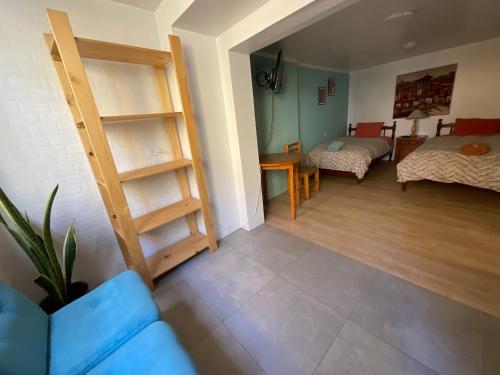 a living room with a blue couch and a bedroom at La Casa de Zarela in Huaraz
