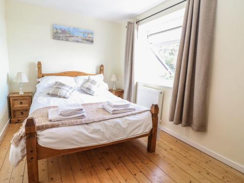 a bedroom with a bed and a window at Bryn Uchaf in Benllech