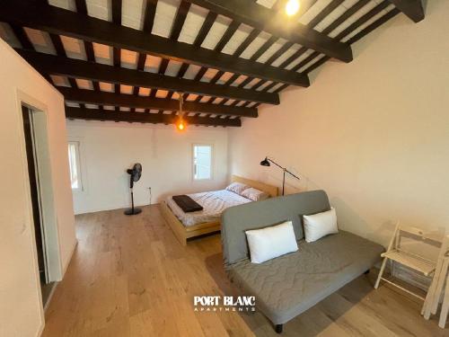 a living room with a couch and a bed at PortBlanc Apartments - 4 in Arenys de Mar