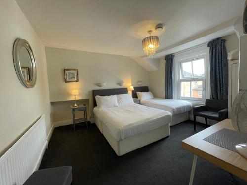 a hotel room with two beds and a chair at Newton House Oxford in Oxford