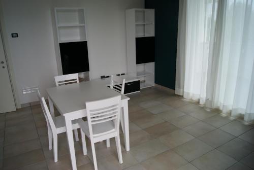 una sala da pranzo con tavolo e sedie bianche di Guest House Residence Malpensa a Case Nuove