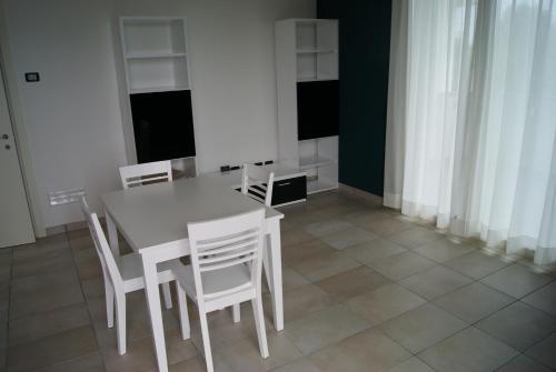 a dining room with a table and white chairs at Guest House Residence Malpensa in Case Nuove