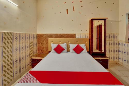 a bedroom with a large bed with red pillows at Hotel O Vaishali Garden in Rānchī
