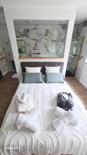 - une chambre avec un lit blanc et des oreillers dans l'établissement Appartement Le Marcky, à Graulhet