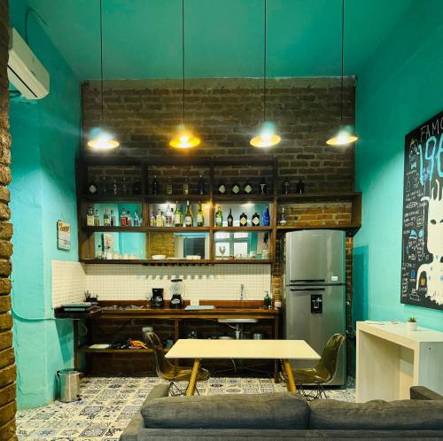 a dining room with a table and a refrigerator at Moonshine Boutique Hostal in Cali