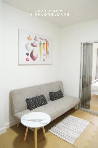 a living room with a couch and a table at Cozy room in Khlongluang - Self Check-in in Khlong Luang
