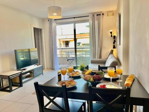 un salon avec une table avec de la nourriture dessus dans l'établissement Eden Blue YourHostHelper, à Antibes