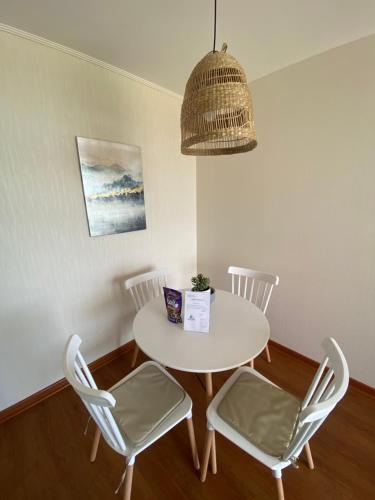 a white table with chairs and a pendant light at Departamento San Fernando in San Fernando