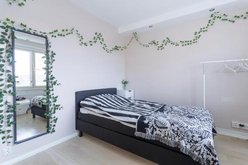 a bedroom with a black and white bed and a mirror at ArcticFox Apartment in Rovaniemi