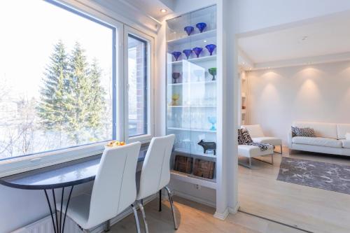 a dining room with a table and chairs and a window at ArcticFox Apartment in Rovaniemi