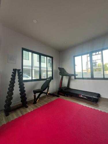 a room with a gym with a treadmill and a red rug at Lub Sabai in Yala