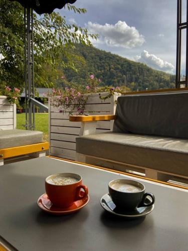 two cups of coffee sitting on top of a table at "Глиняна хатинка" in Beloberëzka