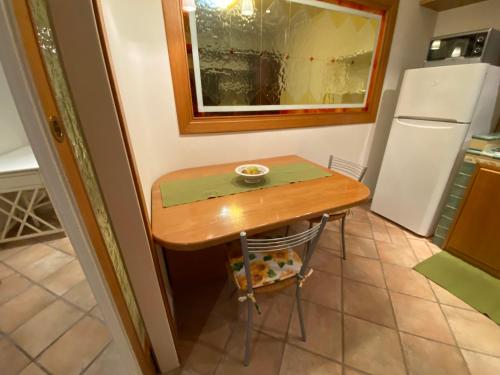 a small kitchen with a small table and a refrigerator at Rhome country lodge in La Massimina-Casal Lumbroso
