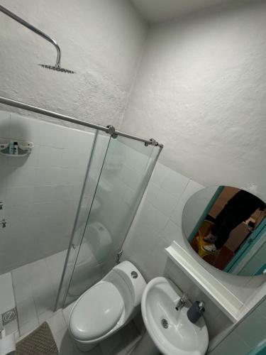 a bathroom with a sink and a toilet and a mirror at Moonshine Boutique Hostal in Cali