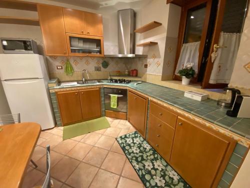 a kitchen with wooden cabinets and a white refrigerator at Rhome country lodge in La Massimina-Casal Lumbroso