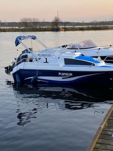 a blue and white boat sitting in the water at Apartament Lake House Zegrze in Zegrze