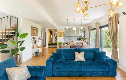a living room with a blue couch and a kitchen at Villa Lux in Donji Zemunik
