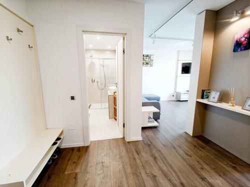 a white room with a bathroom and a hallway with at Lakeside Apartment By Iulius Mall in Cluj-Napoca