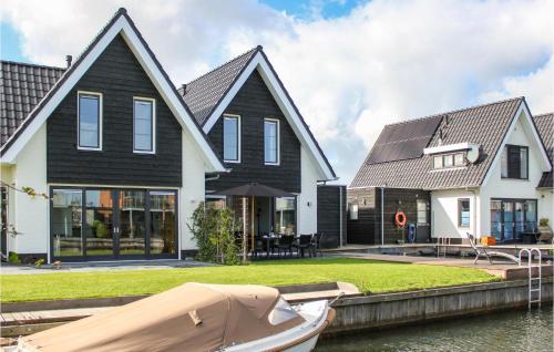 a house with a boat parked in front of it at Cozy Home In Stavoren With Wifi in Stavoren