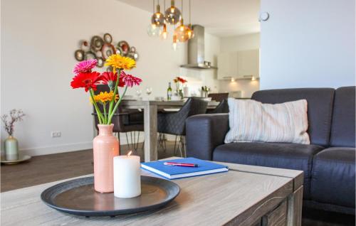 a living room with a table with a candle and flowers at Cozy Home In Stavoren With Wifi in Stavoren