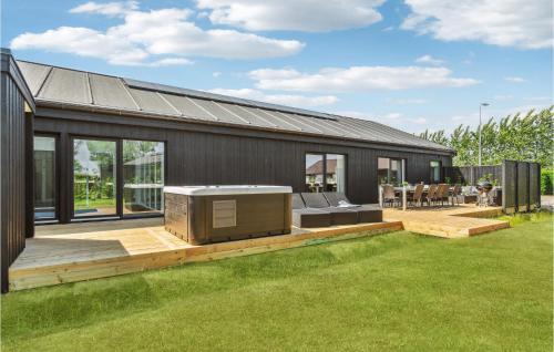 ein Haus mit einer Terrasse mit einem Fernseher darauf in der Unterkunft Lovely Home In Nexø With Sauna in Neksø