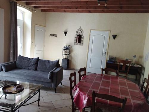 un salon avec un canapé et une table dans l'établissement Gîte ARDELAY et son jardin, 10 min du Grand Parc, aux Herbiers