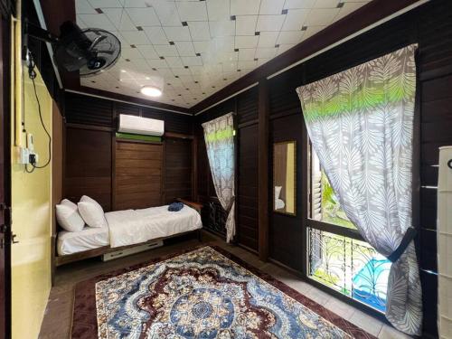 a small room with a bed and a window at Merpati Dusun Retreat in Kepala Batas