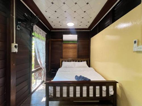 a bedroom with a bed in a room with a window at Merpati Dusun Retreat in Kepala Batas