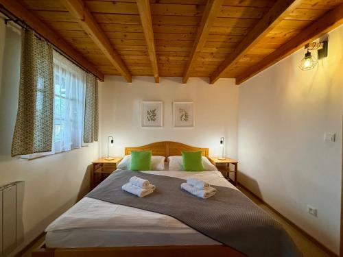 a bedroom with a bed with two green pillows at Chata 107 Tatralandia Village in Liptovský Mikuláš