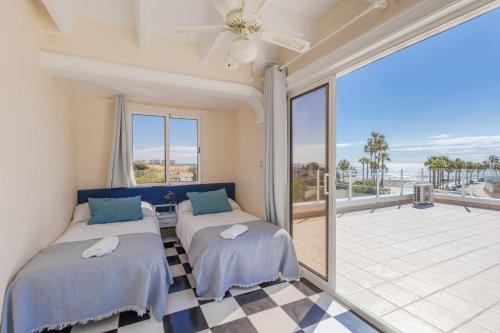 due letti in una stanza con balcone di Fidalsa Prime Mediterranean Beachfront a Orihuela Costa