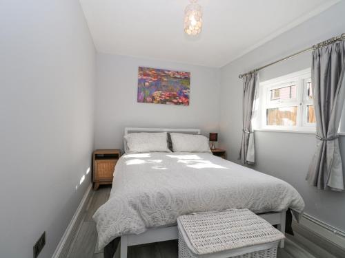 a bedroom with a bed and a painting on the wall at 1 Stonewall Cottages in Billingshurst